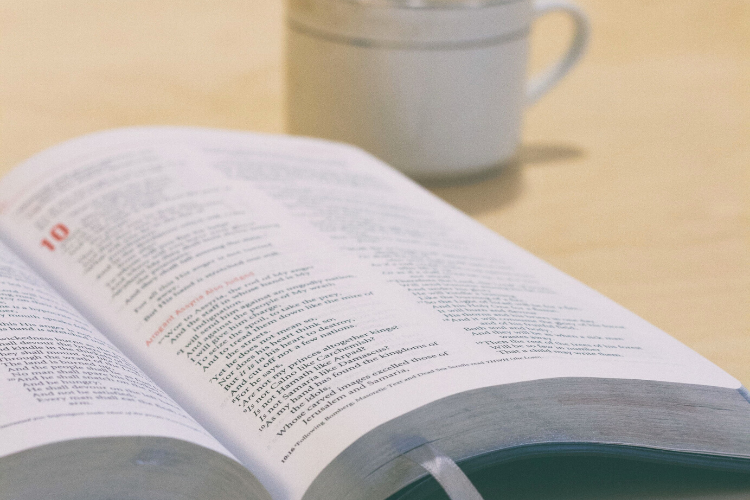 Raamattu ja kahvikuppi.